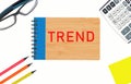 a notepad with the word Trend on a white background . Near glasses, calculator, pencils, paper for writing. Royalty Free Stock Photo