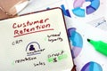 Notepad with words customer retention strategies.