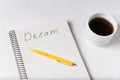 Notepad with the words Dream on white background. Pen coffee on notebook Royalty Free Stock Photo