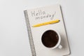Notepad with the words Hello monday on white background. Pen and morning coffee on notebook Royalty Free Stock Photo