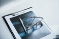 Notepad, x-ray paper, pen and glasses lying on the white table Royalty Free Stock Photo