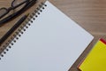Notepad with yellow note and study glasses. Flat lay