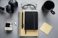 Notepads next to pen, sticky notes, cup of coffee, glasses, smartphone and headphones Royalty Free Stock Photo