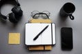 Notepads next to pen, sticky notes, cup of coffee, glasses, smartphone and headphones Royalty Free Stock Photo