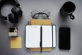 Notepads next to pen, sticky notes, cup of coffee, glasses, smartphone and headphones Royalty Free Stock Photo