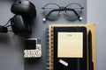 Notepads next to pen, sticky notes, glasses, smartphone and headphones Royalty Free Stock Photo