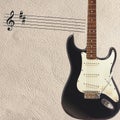 Notes and solid body classic electric guitar on right side of the light skin background. Royalty Free Stock Photo