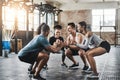 Nothing activates the glutes like squatting. a group of young people doing squats together during their workout in a gym Royalty Free Stock Photo