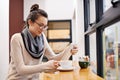 Nothing beats coffee and a good book. an attractive young woman surfing the net in a coffee shop. Royalty Free Stock Photo