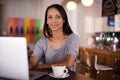 Nothing better than coffee and free wifi. Portrait of a woman using her laptop at a coffee shop. Royalty Free Stock Photo