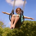 Nothing better than a swing. Shot of a young girl playing on a swing outsdie. Royalty Free Stock Photo