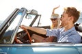 Nothing but blue skies and freedom. A happy young couple driving in a convertible on a bright summers day.