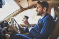 Nothing can spoil his mood. a cheerful young businessman driving in his car to work while sitting in traffic and