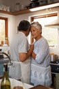 Nothing comes closer to the comfort of love. Shot of a happy mature couple dancing together while cooking in the kitchen Royalty Free Stock Photo