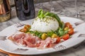 Fresh buffalo mozzarella with basil, rucula and freshly sliced parma ham