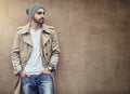 Nothing completes streetwear style than swag. a fashionable young man wearing urban wear and posing against a brown wall Royalty Free Stock Photo