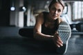 Nothing distracts her from reaching her fitness goals. an attractive young woman stretching during her workout in a gym.