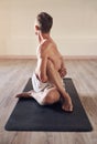 Nothing is ever a stretch too far for him. Full length shot of a flexible young man exercising and stretching in yoga Royalty Free Stock Photo