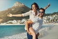 Nothing but freedom. a handsome young man giving his girlfriend a piggyback ride at the beach. Royalty Free Stock Photo