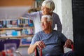 Nothing gets us down. Shot of a senior woman pushing her husband in a wheelchair at home. Royalty Free Stock Photo