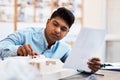 Nothing goes unnoticed. a young architect designing a building model in a modern office. Royalty Free Stock Photo