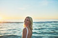 Nothing like fresh ocean air. Cropped portrait of an attractive young female smiling over her shoulder on the beach at Royalty Free Stock Photo