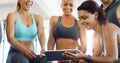 Nothing like a little muscle motivation courtesy of the internet. a group of happy young women using a digital tablet