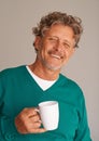 Nothing refreshes him more than a cup of coffee. Portrait of a handsome mature man standing in a studio holding a mug. Royalty Free Stock Photo