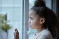 Nothing ruins a summers day like rain. a little girl starting out of the window looking sad at home. Royalty Free Stock Photo