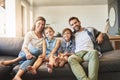 Nothing says home like the love of family. a happy family of four relaxing together on the sofa at home. Royalty Free Stock Photo