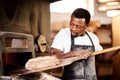 Nothing taste better than bread made with love. a male baker removing freshly baked bread from the oven.