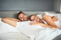 Nothing wrong with a bit of laziness now and then. a happy young couple relaxing in bed together at home.