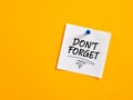 The notice reminder don`t forget written on a note paper pinned on a yellow board Royalty Free Stock Photo