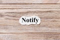 Notify of the word on paper. concept. Words of notify on a wooden background