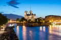 Notre Dame de Paris with cruise ship on Seine river at night in Royalty Free Stock Photo