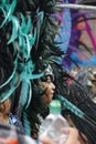 NOTTING HILL, LONDON - AUGUST 27, 2018: Notting Hill Carnival, side-on view of woman wearing large feathery headpiece in the parad