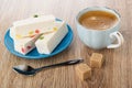 Nougat with marmalade in saucer, coffee in cup on saucer, spoon, sugar on wooden table Royalty Free Stock Photo