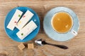 Nougat with marmalade in saucer, coffee in cup on saucer, spoon, sugar on wooden table. Top view Royalty Free Stock Photo