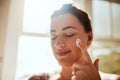 Nourished skin is happy skin. an attractive young woman applying moisturiser during her morning beauty routine.
