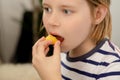 Nourishing bite: A young boy takes a nourishing bite of a juicy yellow plum, relishing the healthful fruit goodness