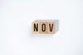 ` NOV ` text made of wooden cube on White background