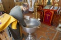 The village of Berezki. Local church. The rite of Orthodox baptism. The priest reads a prayer at the baptismal font Royalty Free Stock Photo