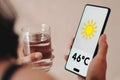 Woman holds a glass of water, the thermometer showing 46ÃÂºC of heat is Royalty Free Stock Photo