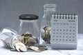 November 2024 calendar and glass jars with multicurrency coins.