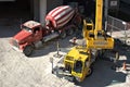 A cement truck and a crane work together to deliver material to higher levels.