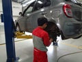 A technician is doing repairs on the brake system of a 4-wheeled vehicle at a workshop