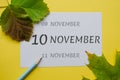 10 november day of month on a white sheet and the dates of the day earlier and later, written in simple pencil. Decoration with