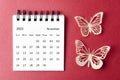 A November 2023 desk calendar for the organizer to plan and reminder with paer butterfly on red background Royalty Free Stock Photo