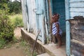 Dramatic image of small Haitian child standing in her doorway of their home looking for her mother.