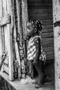 Dramatic black and white image of a cute Haitian child looking outside for her mother.